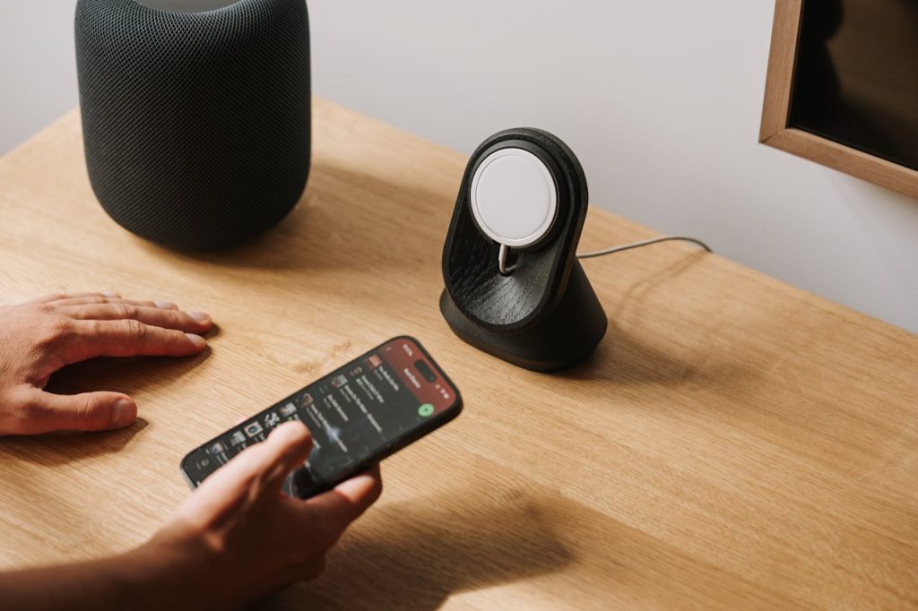 pexels-photo-19238583 A modern desk setup featuring tech gadgets with a smartphone and smart speaker.
